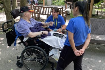 At Donald Berman Jewish Eldercare, MISSIVE student volunteers Caressa Jaime (standing) and Simona Strbova chat with resident Harvey Lipstein.